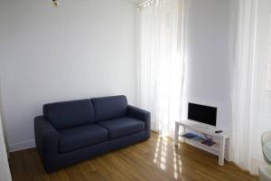 un sofá azul en la sala de estar con TV en Quartier Historique du Château bel appt meublé, en Pau