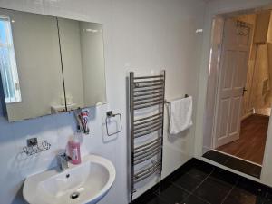 uma casa de banho com um lavatório, um espelho e um chuveiro em Chester Le Street's Diamond 3 Bed House em Chester-le-Street