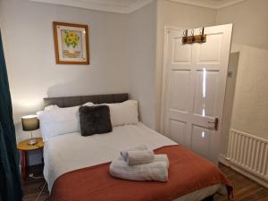 Un dormitorio con una cama blanca con toallas. en Chester Le Street's Diamond 3 Bed House, en Chester-le-Street