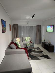 a living room with a couch and a tv at Craiden Holiday Apartment at The Blyde Crystal Lagoon 2 bedrooms in Pretoria