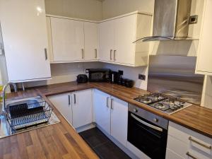 a kitchen with white cabinets and a stove top oven at Chester Le Street's Diamond 3 Bed House in Chester-le-Street