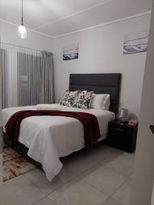 a bedroom with a large bed with a black headboard at Craiden Holiday Apartment at The Blyde Crystal Lagoon 2 bedrooms in Pretoria +20 photos