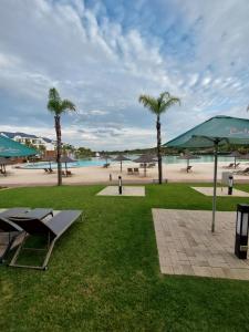 un parque con palmeras y una playa de arena en Craiden Holiday Apartment at The Blyde Crystal Lagoon 2 bedrooms en Pretoria