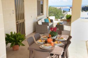 un tavolo con piatti di cibo su un balcone di Villa Margherita a Ix-Xagħra taʼ Barra