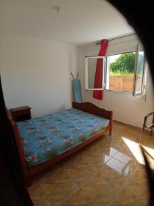 een slaapkamer met een bed in een kamer met een raam bij Sababady Villa 3 chambres in Saint-André