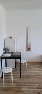 a black table and two white chairs in a room at Elli apartament in Gdynia