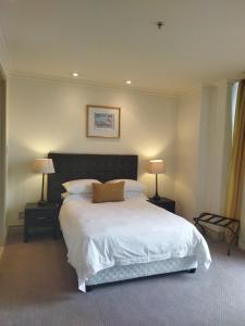 a bedroom with a large white bed with two lamps at Michelangelo Towers 0801 in Johannesburg