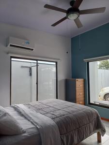 - une chambre avec un lit et un ventilateur de plafond dans l'établissement Casa con piscina, à Portegolpe
