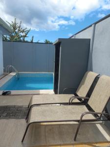 une paire de chaises assises à côté de la piscine dans l'établissement Casa con piscina, à Portegolpe