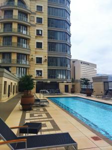 ein Schwimmbad vor einem hohen Gebäude in der Unterkunft Michelangelo Towers 0801 in Johannesburg
