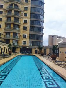 a large swimming pool in front of a building at Michelangelo Towers 0801 in Johannesburg