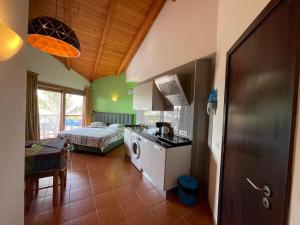 a room with a kitchen and a bedroom with a bed at studio's Porto Antigo 2 in Santa Maria