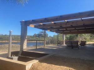 a pavilion with two chairs and a table on the beach at De Poort Cottage in Bredasdorp