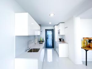 uma cozinha com armários brancos e uma porta azul em Apartment in Manilva, just a few steps from the beach em Manilva