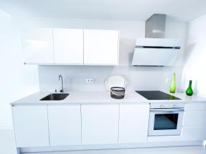 uma cozinha branca com armários brancos e um lavatório em Apartment in Manilva, just a few steps from the beach em Manilva