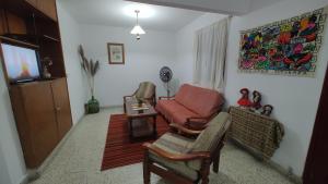 sala de estar con sofá y silla en Casa Kuyay en San Salvador de Jujuy