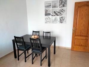 una mesa de comedor negra y sillas en una habitación en City Centre Arrecife en Arrecife