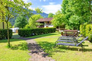 a park with benches and a table in the grass at Casa Elena in Ledro