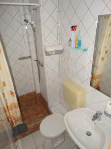 a bathroom with a shower and a toilet and a sink at Aqua Ház Panzió 4 J in Balatonfüred