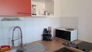una cucina con piano di lavoro e forno a microonde di Les soleiades a Béziers