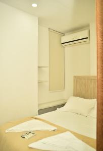 een slaapkamer met een wit bed en een ventilator bij Magico Apartamento Frente al Mar 3 Habitaciones CV41 in Coveñas