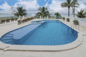een groot zwembad met blauw water voor de oceaan bij Magico Apartamento Frente al Mar 3 Habitaciones CV41 in Coveñas