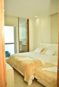 een slaapkamer met 2 bedden en een spiegel bij Magico Apartamento Frente al Mar 3 Habitaciones CV41 in Coveñas
