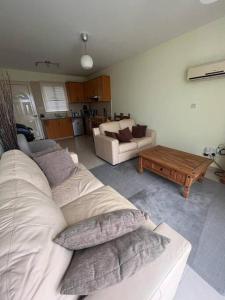 - un salon avec un canapé blanc et une table dans l'établissement Apartament na Cyprze, à Peyia