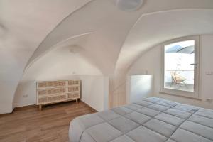 ein Schlafzimmer mit einem großen Bett und einem Fenster in der Unterkunft Doberdò Exclusive House & SPA Bath - SIT Apartment in Carmiano
