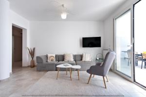un soggiorno bianco con divano e tavolo di Doberdò Exclusive House & SPA Bath - SIT Apartment a Carmiano