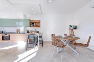 eine Küche mit einem Tisch und Stühlen im Zimmer in der Unterkunft Doberdò Exclusive House & SPA Bath - SIT Apartment in Carmiano