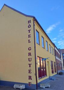 un edificio amarillo con un cartel en el costado en Sveriges minsta Hotell! Hôtel Gruyère, en Landskrona