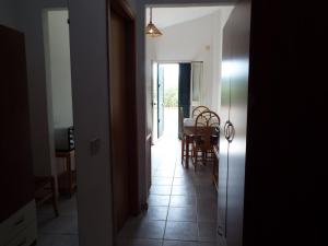 un couloir avec une salle à manger, une table et des chaises dans l'établissement La Grazia, à Parghelia