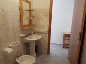 a bathroom with a sink and a toilet and a mirror at La Grazia in Parghelia