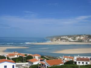 a view of a beach with houses and the ocean at Pipo People House in Óbidos
