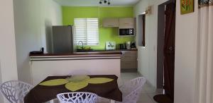 a kitchen with a table and chairs in a room at Paisible maison à Vieux-Habitants in Vieux-Habitants