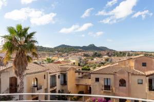 a view of a city with a palm tree and buildings at New Ca'Mea in Villasimius