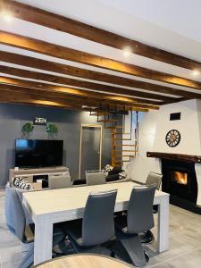 a dining room with a table and chairs and a fireplace at Superbe villa apaisante, vue sur la loue in Mouthier-Haute-Pierre