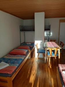 Zimmer mit 4 Etagenbetten und einem Tisch in der Unterkunft Rulfik in Hinterberg