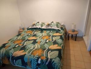 a bedroom with a bed with a colorful comforter at bleu intense in La Trinité