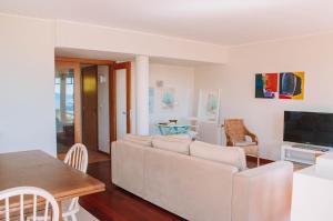 a living room with a white couch and a table at Just like Home - Number 8 em Quinta das Mineirinhas in Vila Nova de Cerveira +25 photos