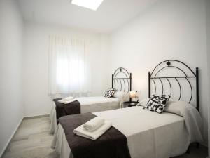 エル・プエルト・デ・サンタマリアにあるColon 1の白いベッドルーム(ベッド2台、窓付)