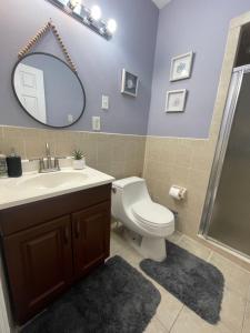 a bathroom with a toilet and a sink and a mirror at Verdana Rental NJ in North Bergen