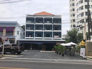 a large building with a blue awning next to a street at Emma in Ban Pak Khlong Phe