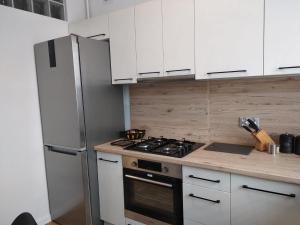 una cucina con armadi bianchi e piano cottura di Apartament Gustav a Zawiercie