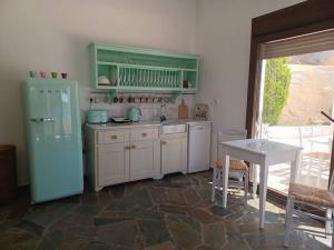 uma cozinha com um frigorífico verde e uma mesa em Spectacular Seaview Apartment em Alinda