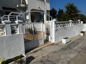 a white gate in front of a house at casamare 69 in Torre Canne