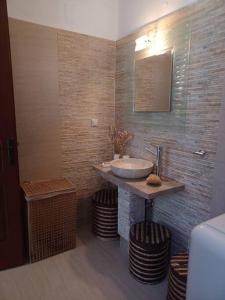 baño con lavabo, 2 taburetes y espejo en Spectacular Seaview Apartment, en Alinda