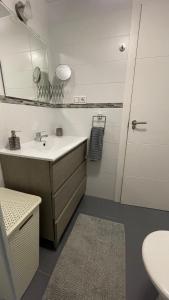 ein weißes Badezimmer mit Waschbecken und Spiegel in der Unterkunft Isla Verde Apartment in Torrevieja + 32 Fotos