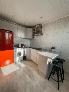 a kitchen with an orange refrigerator and a counter at Marijampole Apartment in Marijampolė